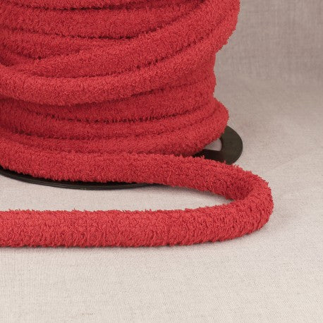 Red polyester cord with loops for bags on a spool.