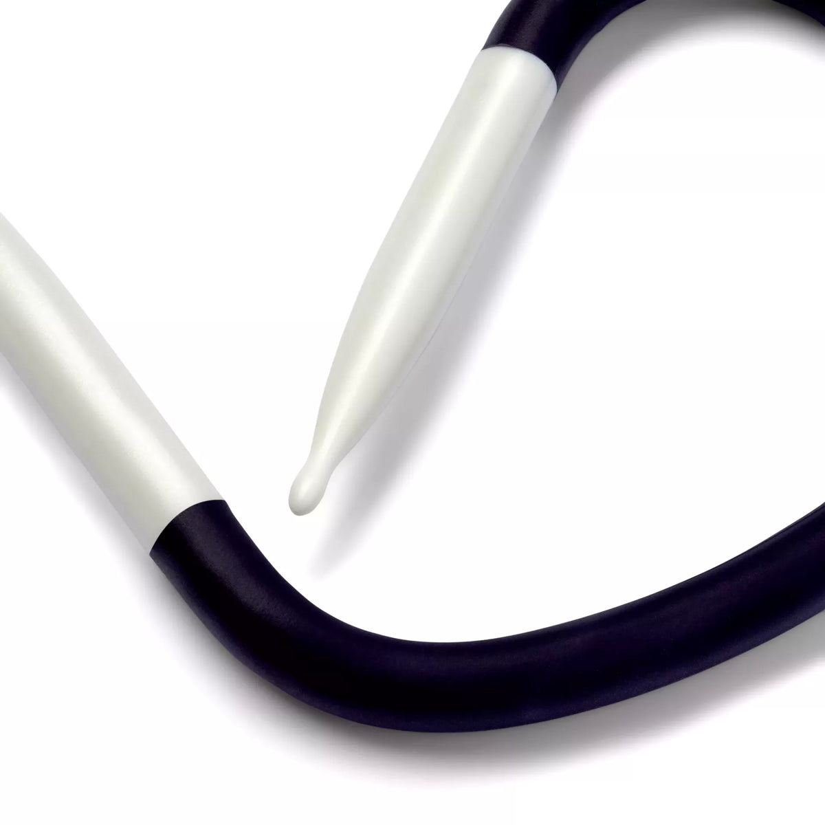 Close-up of a 7.0 mm Yoga cable-stitch needle with a flexible violet shaft and white drop-shaped tips
