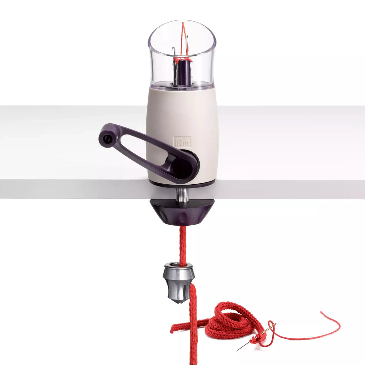 Violet and white Comfort Twist knitting mill clamped to a table, producing a red knitted tube.