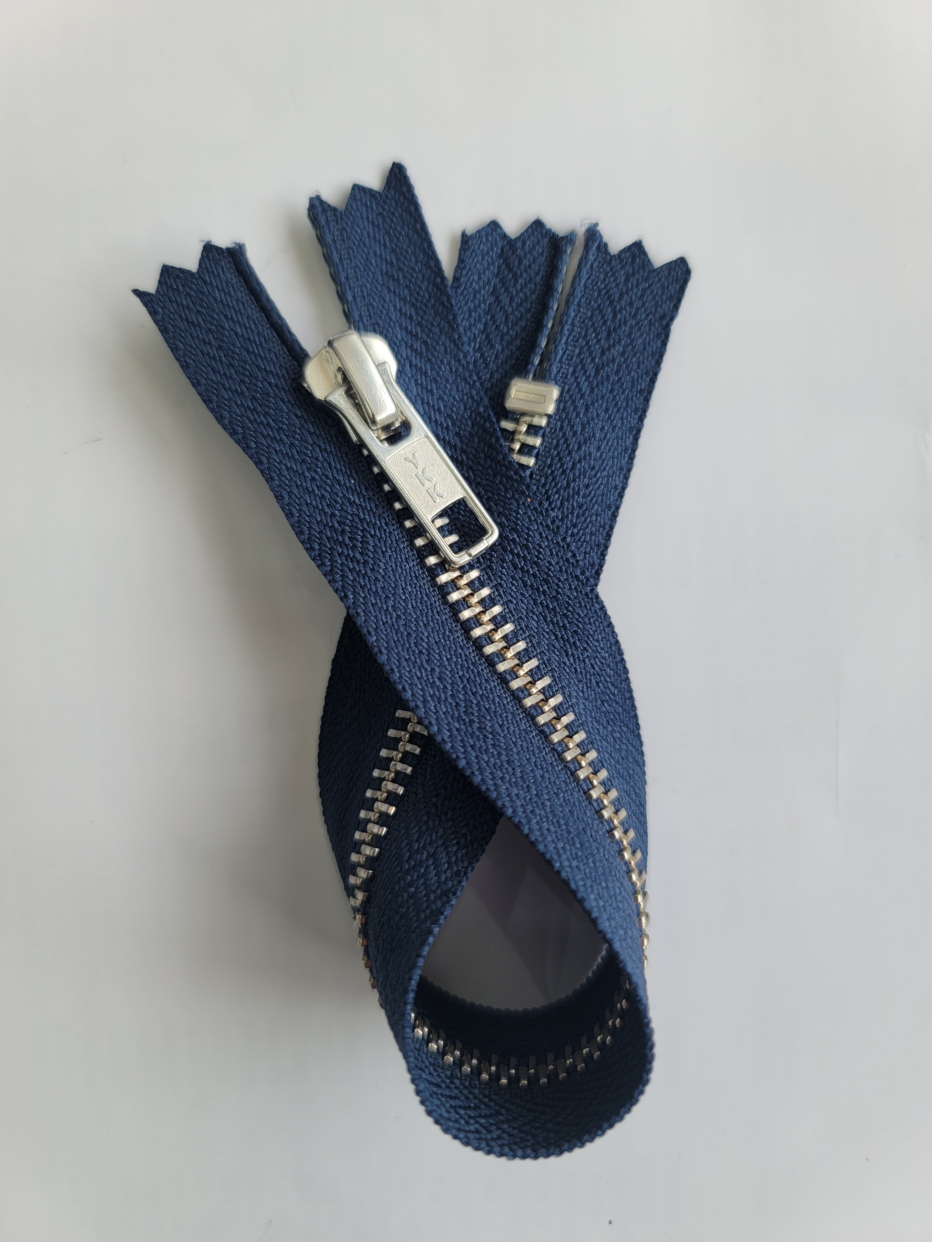 YKK silver metal C5 closed end zip with dark blue tape.