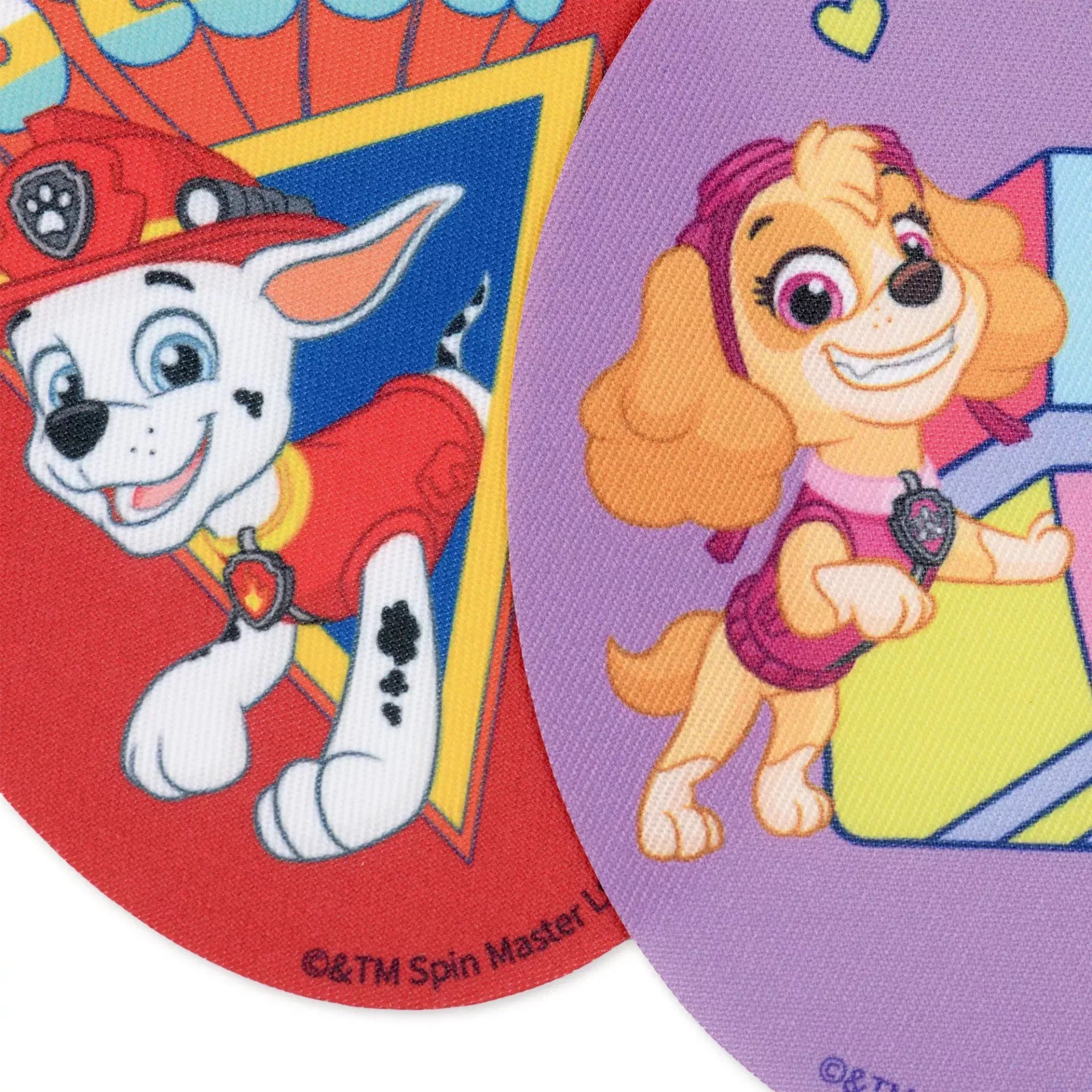 Multicoloured oval iron-on patches featuring Paw Patrol characters Marshall and Skye.