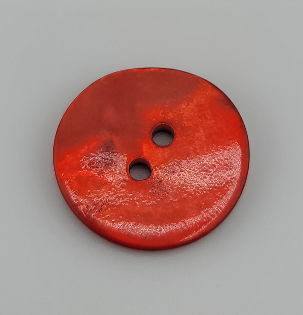 Red shell button with two holes and a glossy finish.