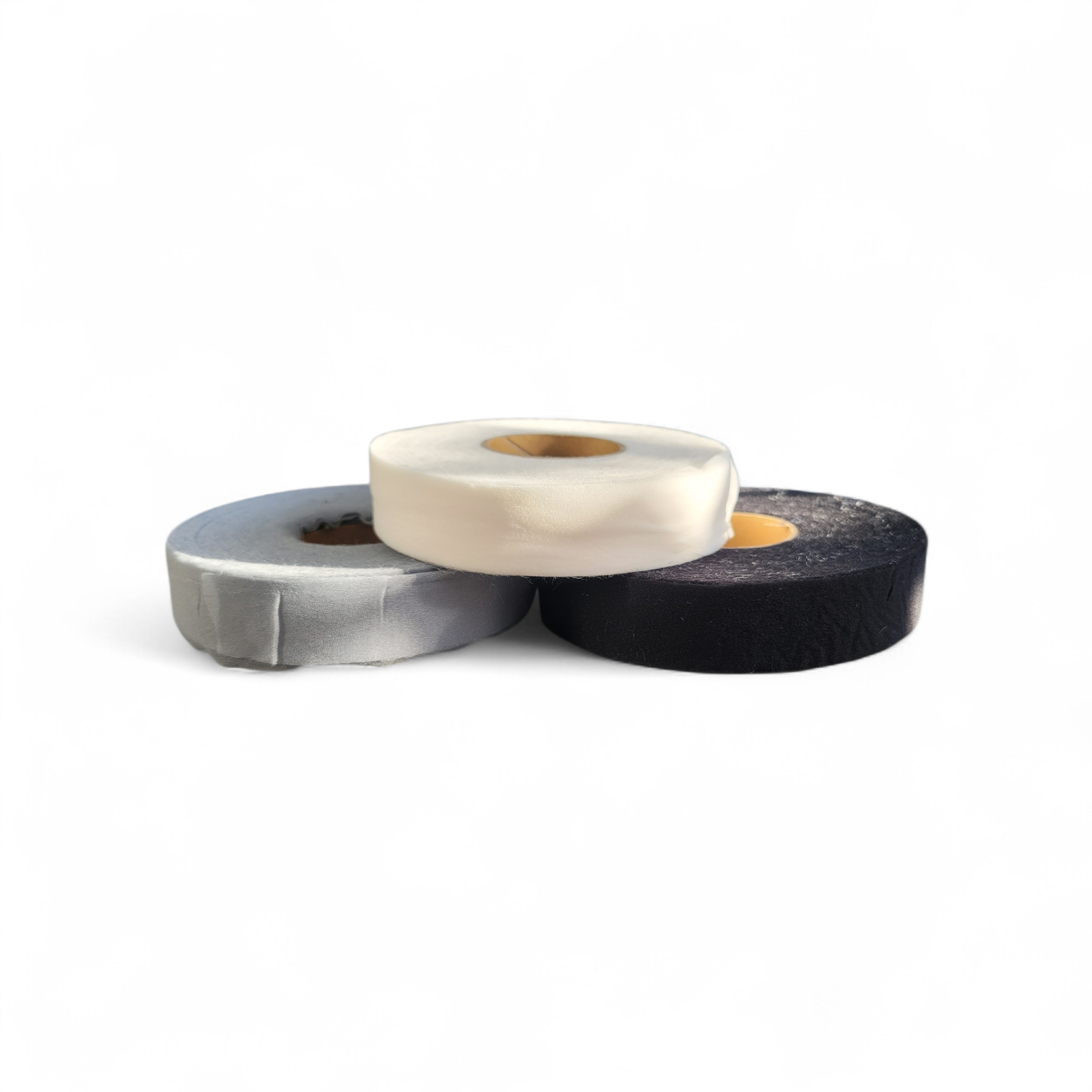 Three rolls of fusible interlining tape in white, black, and grey.