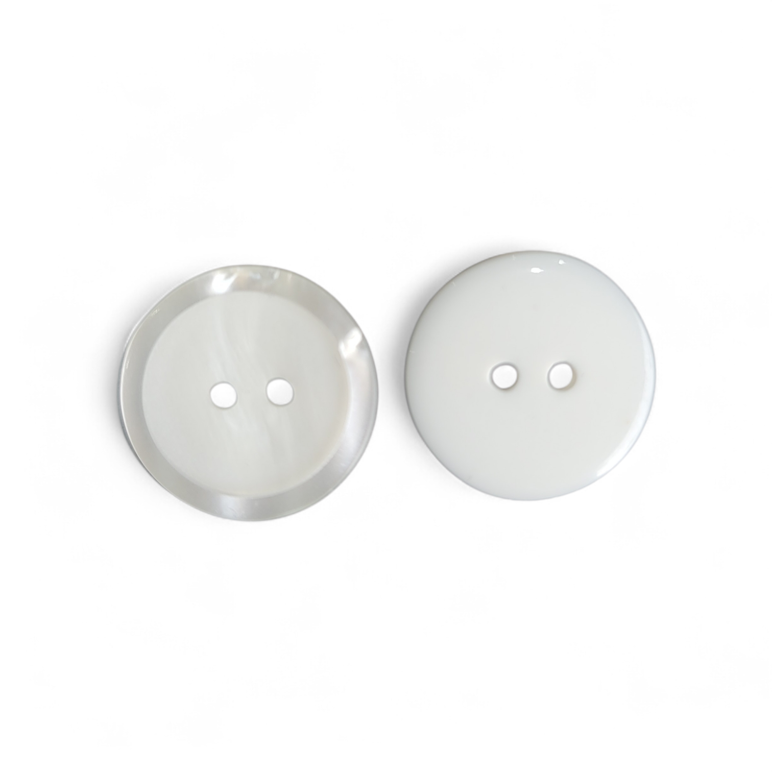 Two ivory imitation pearl polyester buttons with two holes each.