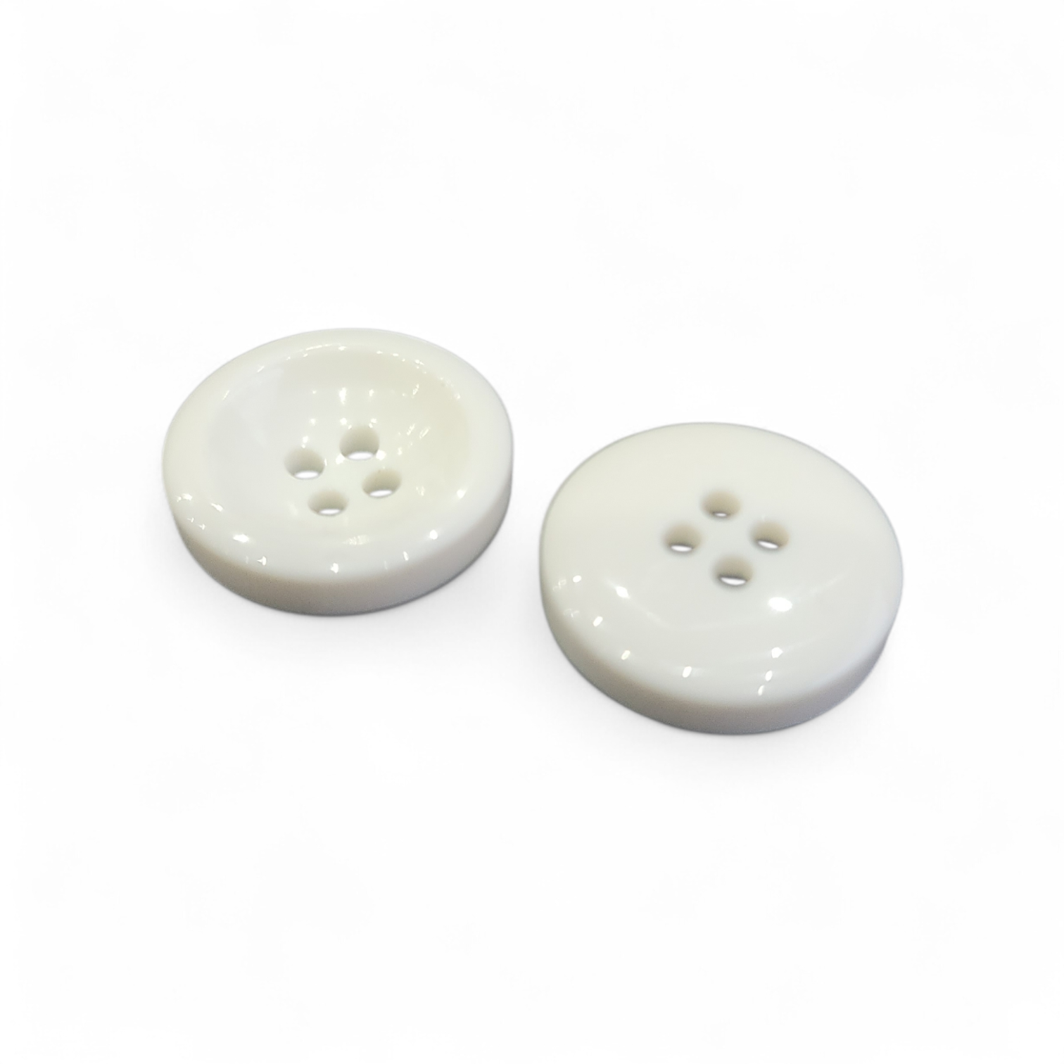 Two 23mm white plastic scooped buttons with four holes shown on a white background.