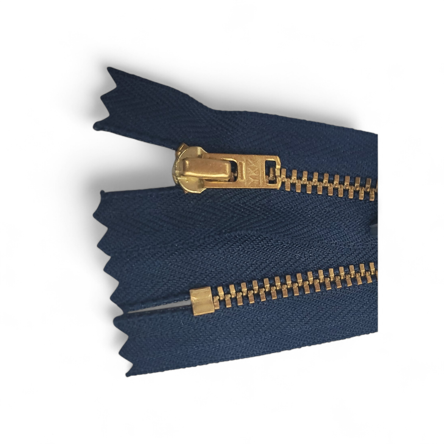 YKK Size 3 closed end gold metal zipper with navy blue fabric.