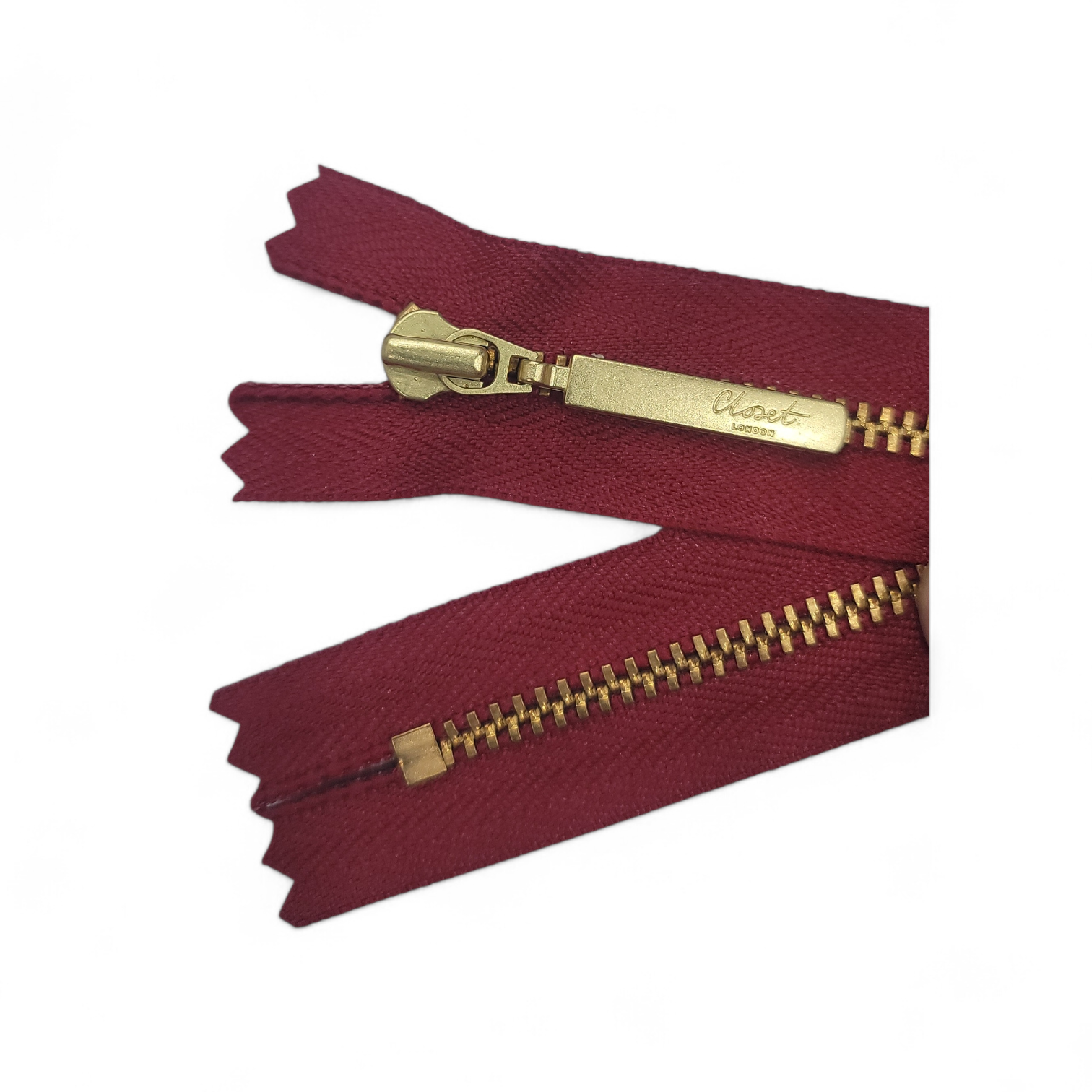 YKK size 3 closed end gold metal zip with burgundy tape.