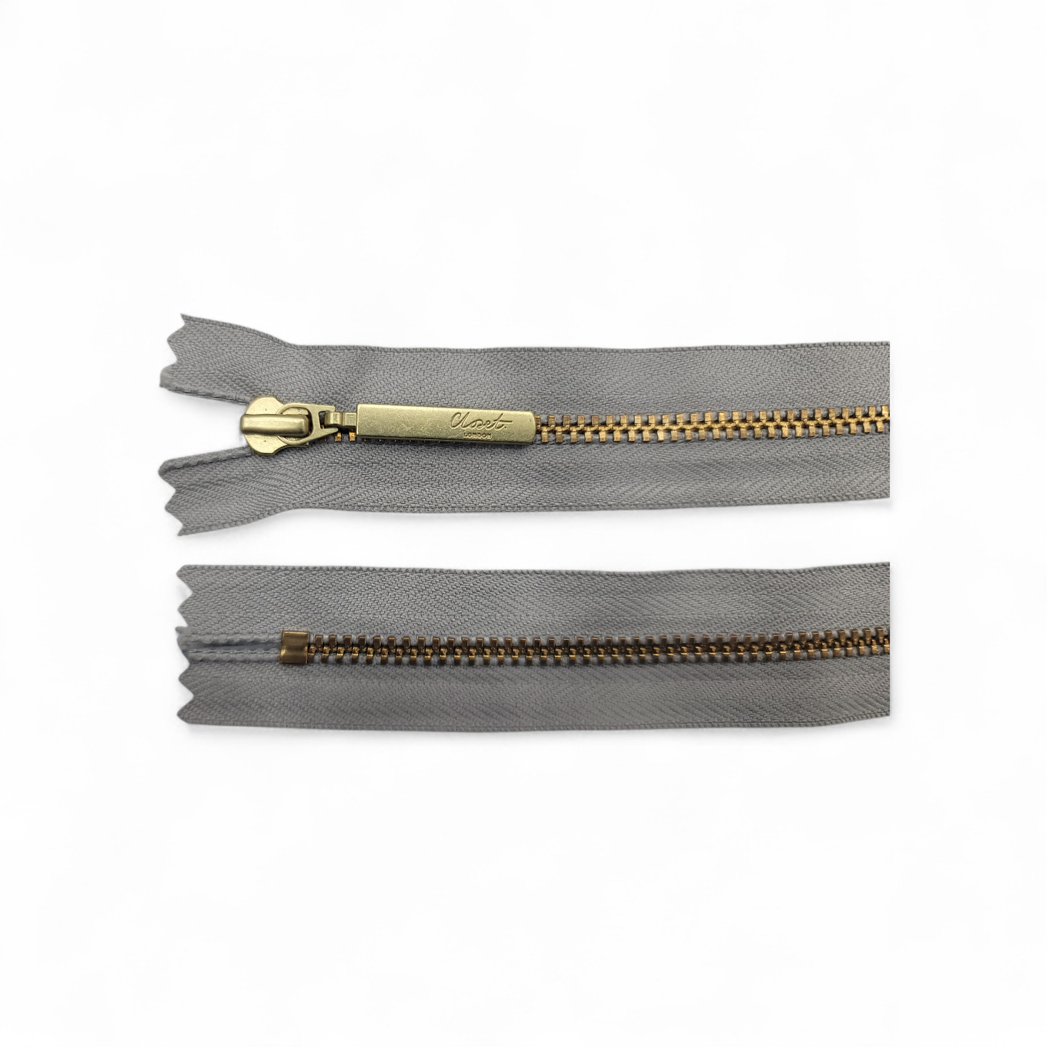 YKK size 3 closed end gold metal zip with grey fabric.
