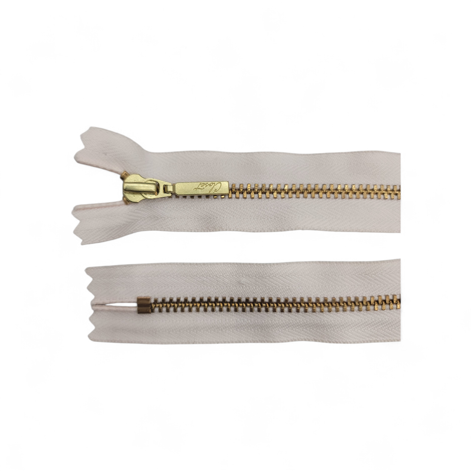 YKK size 3 closed end gold metal zipper with white tape.