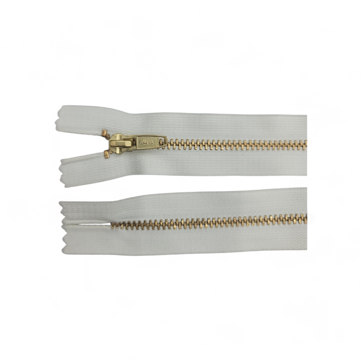 YKK size 3 closed end gold metal zipper with white tape.