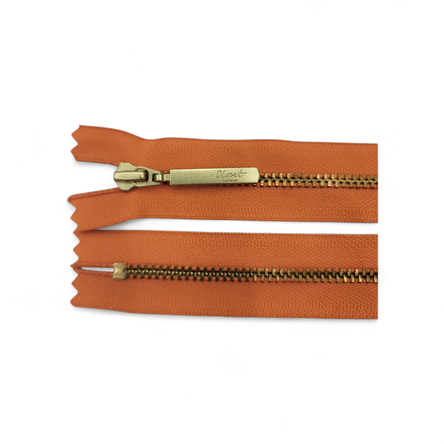 YKK size 3 closed end gold metal zipper with orange tape.