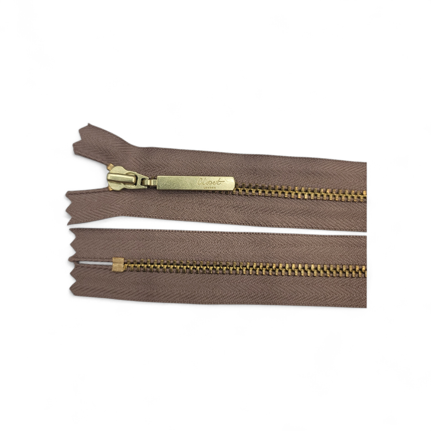 YKK size 3 closed end gold metal zipper with brown tape.