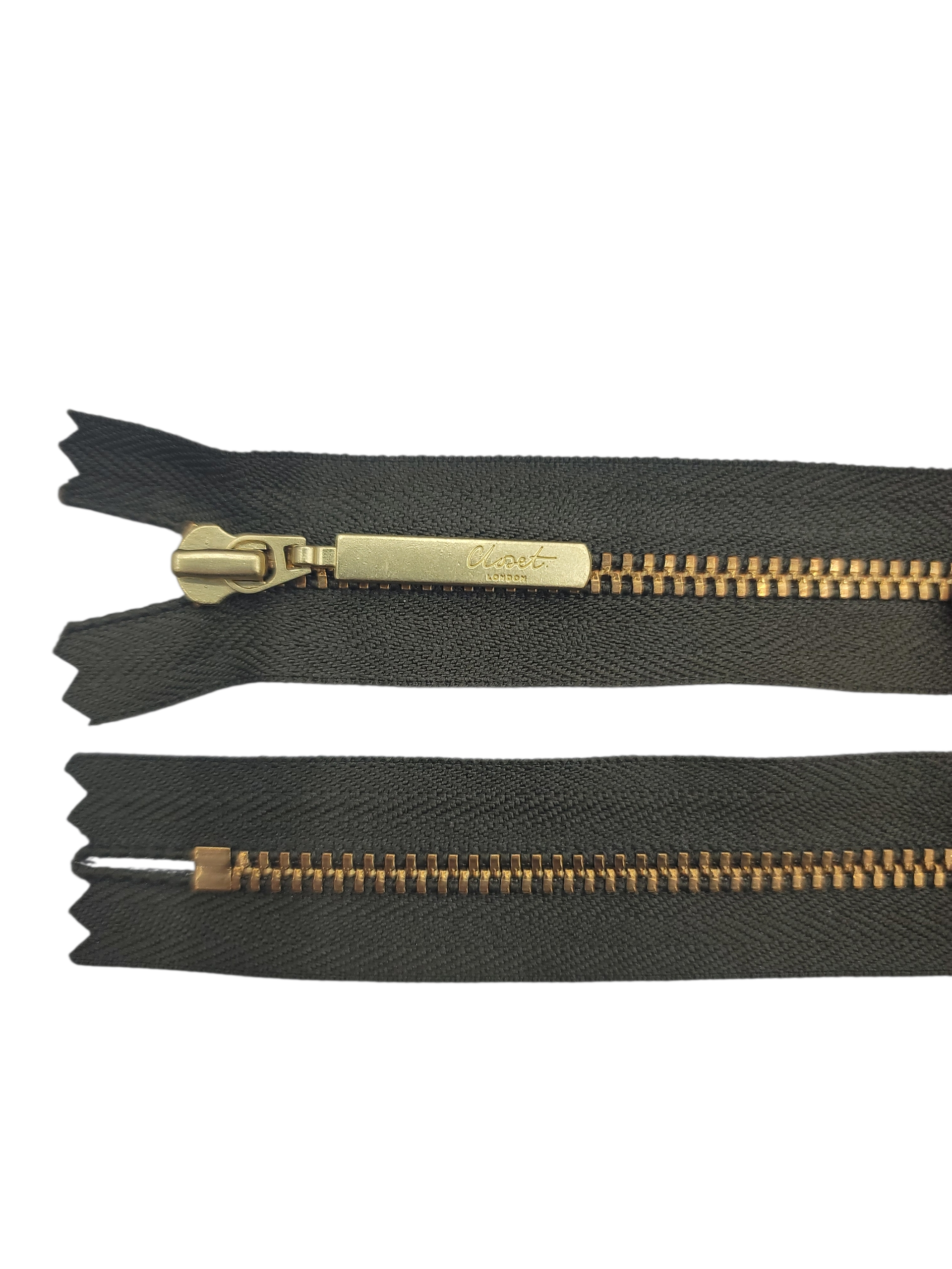 YKK size 3 closed end gold metal zip with black tape.