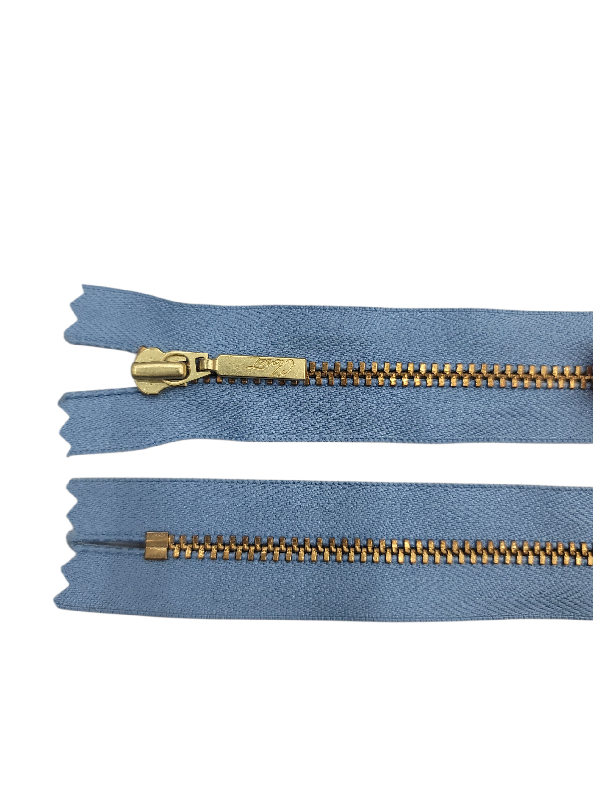 YKK size 3 closed end gold metal zipper on blue fabric.