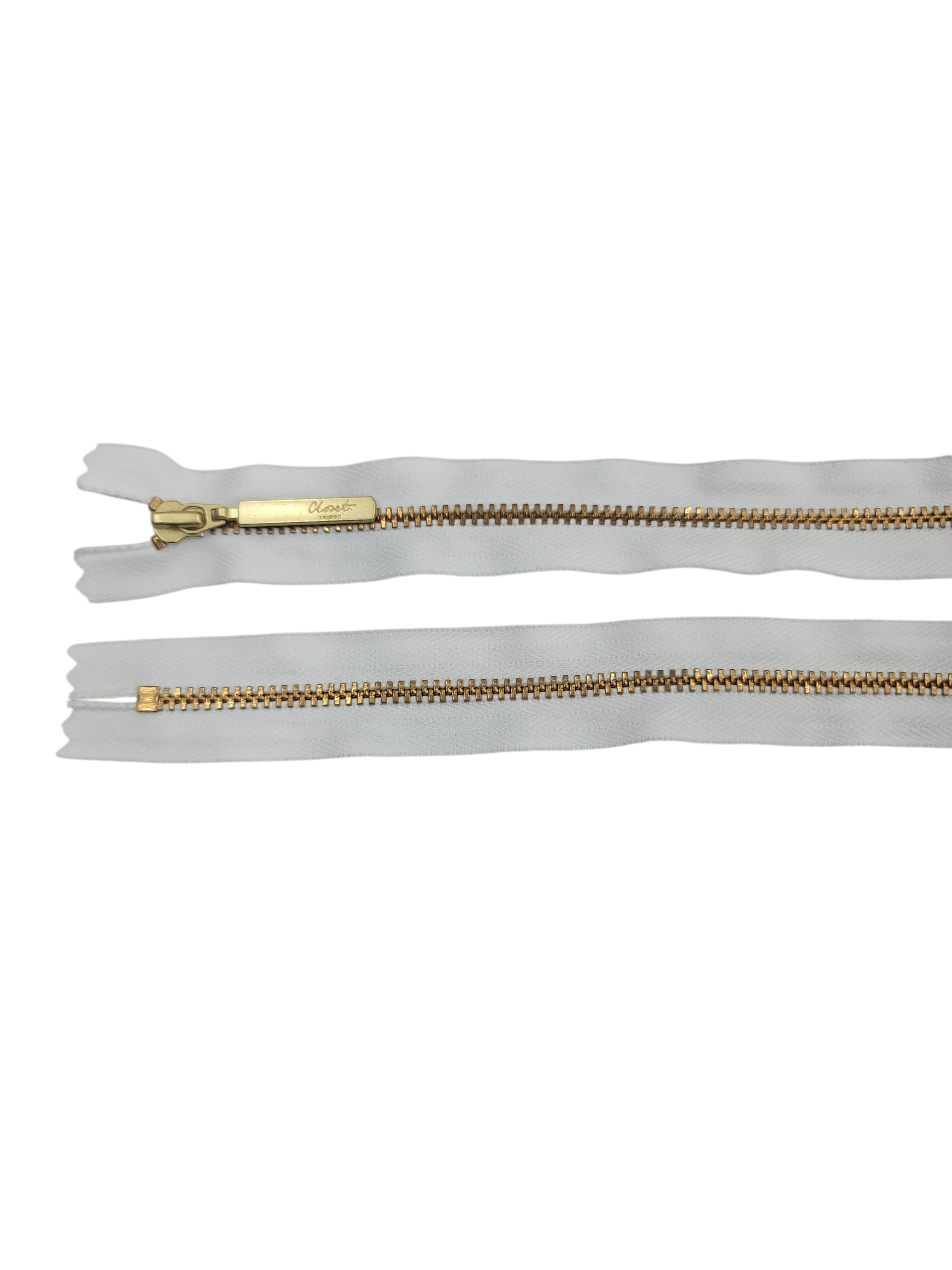 YKK size 3 closed end gold metal zip with white tape.
