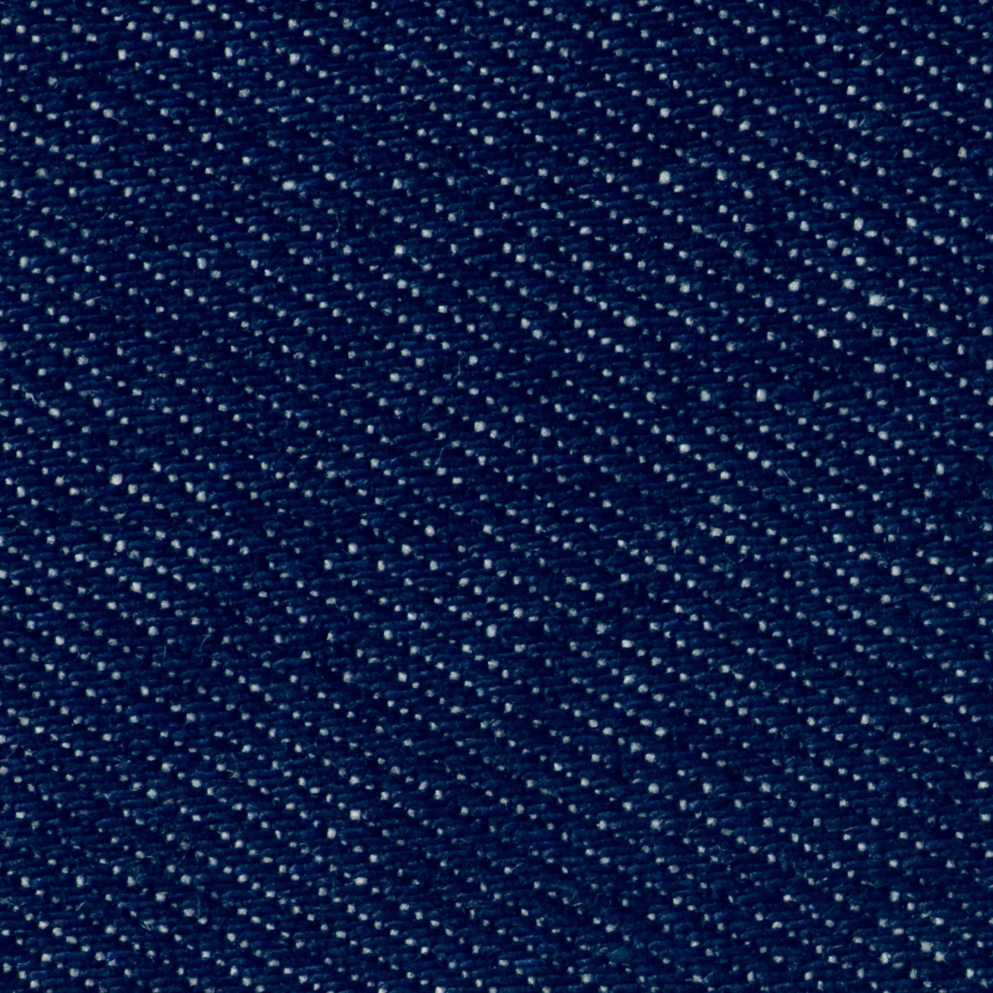 Dark blue denim fabric with a diagonal weave and white flecks.