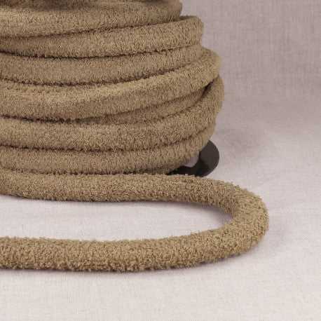 A coil of thick, looped, tan polyester cord for bags.