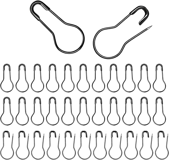 A collection of black metal bulb safety pins in closed and open positions on a white background.