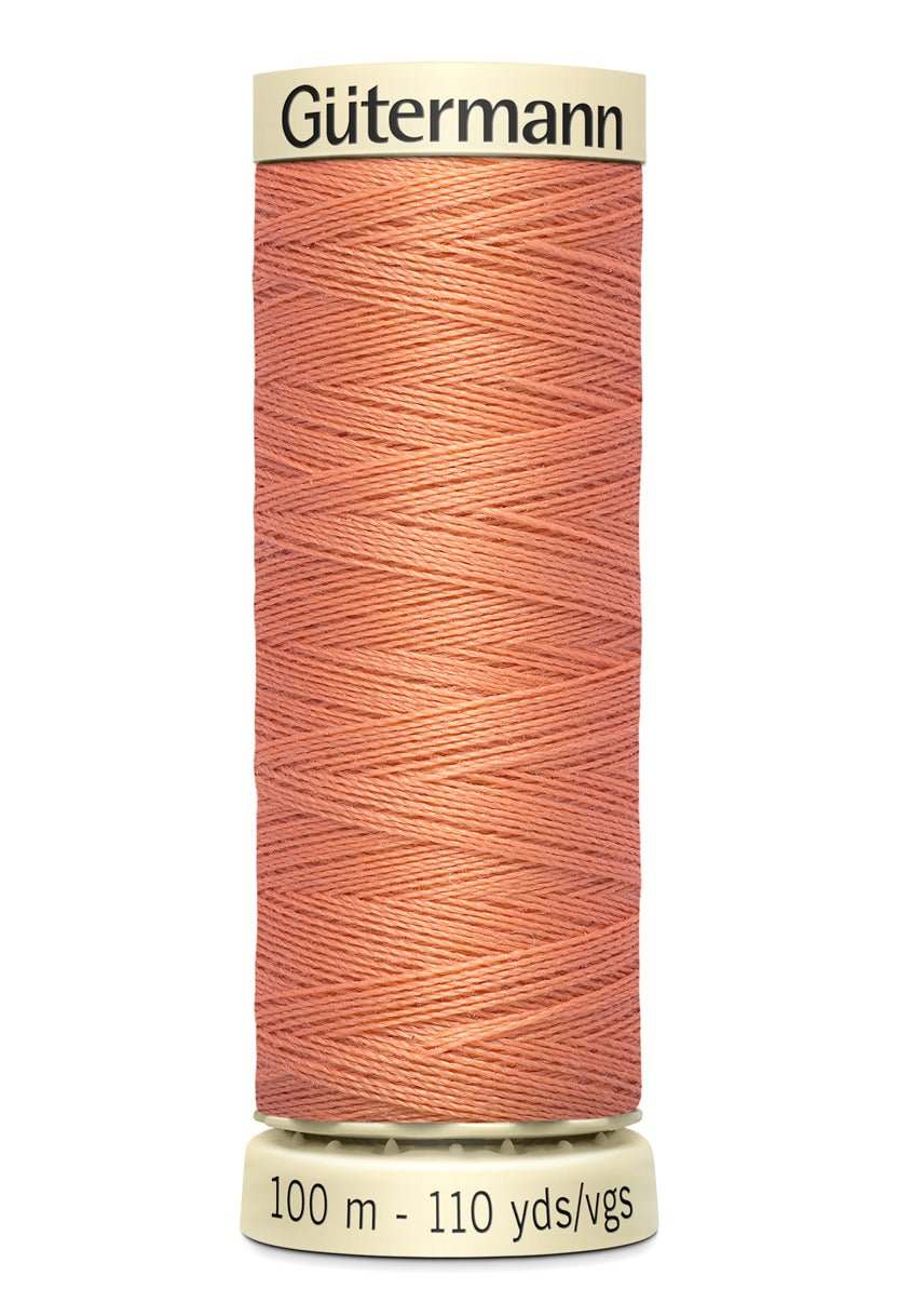 Gütermann Sew-All thread in a coral color on a 100m spool.