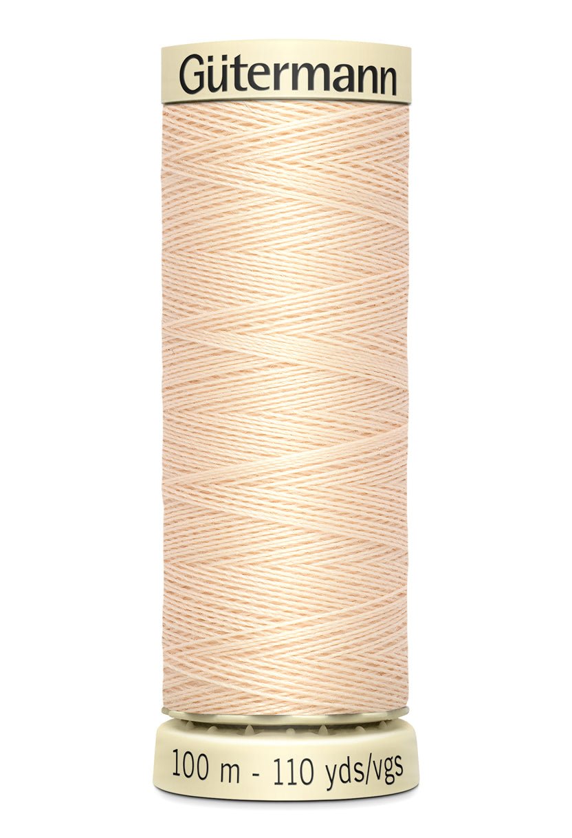 Gutermann Sew-All thread in a light peach color on a spool.