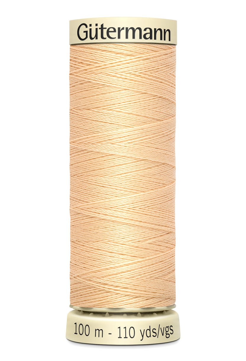 Gutermann Sew-All thread in a light peach color on a spool.
