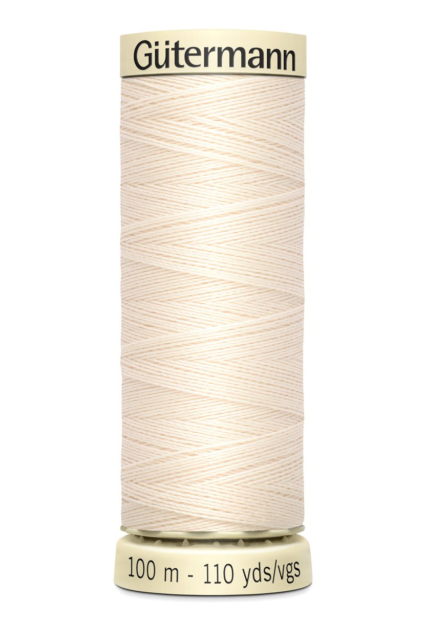 Gutermann Sew-All thread in a light cream color on a spool.