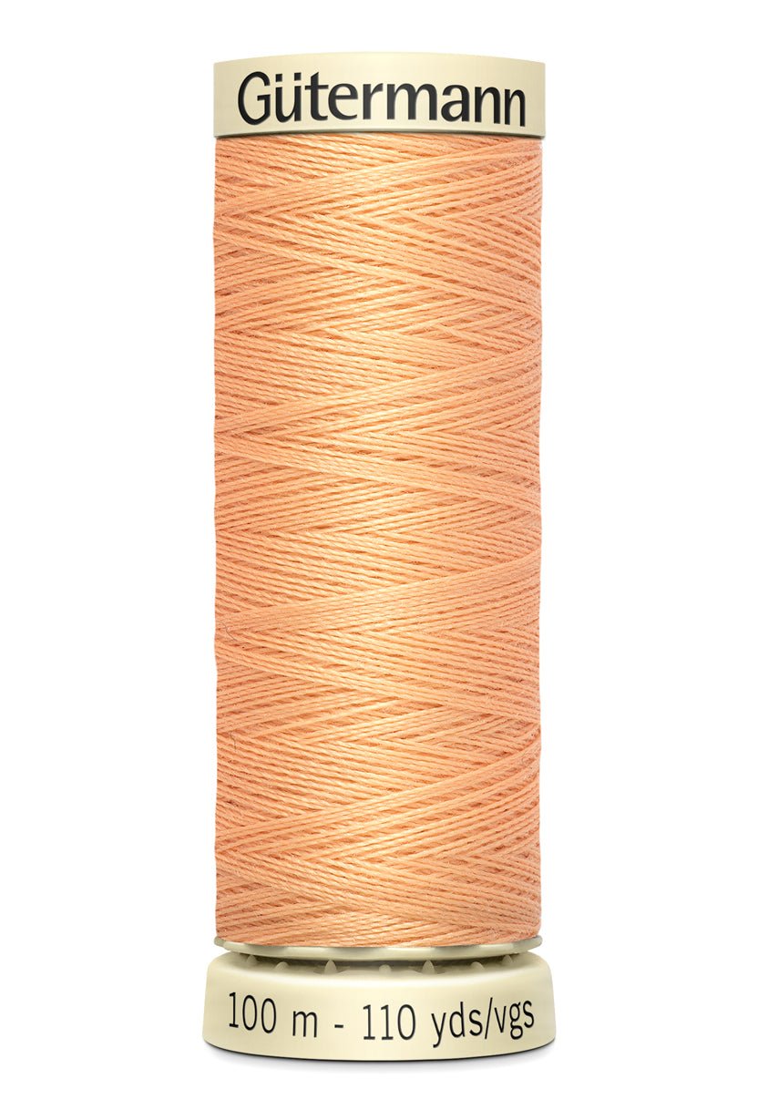 Gutermann Sew-All thread in a light peach color on a spool.