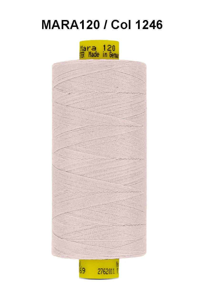 A spool of light pink Gutermann Mara 120 thread with product information printed on the label.