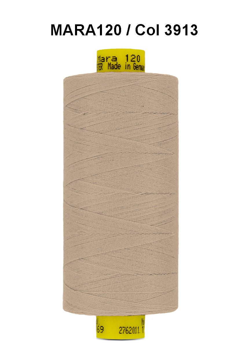 A spool of tan Gutermann Mara 120 thread with product information on the label.