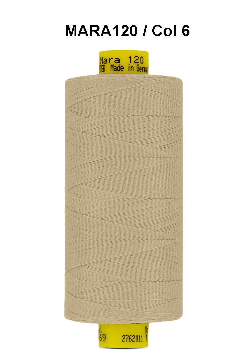 A spool of tan Gutermann Mara 120 thread with product information printed on the spool.