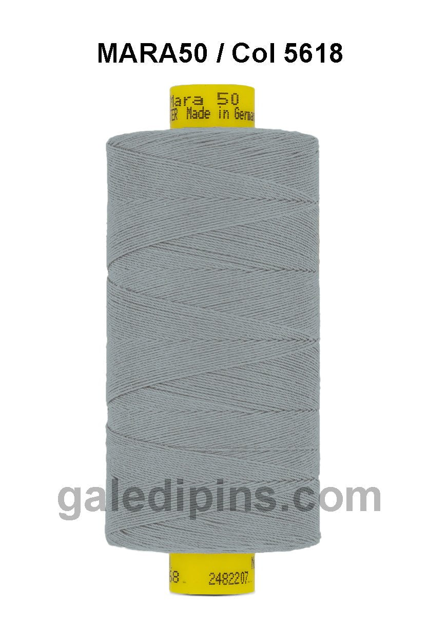 A spool of grey Gutermann Mara 50 thread with yellow labeling.