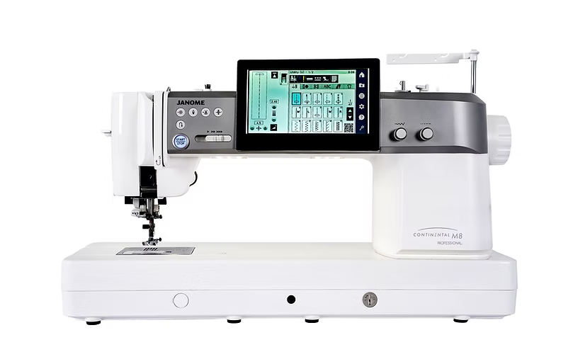 A white Janome Continental M8 Professional sewing machine with a color touchscreen display.