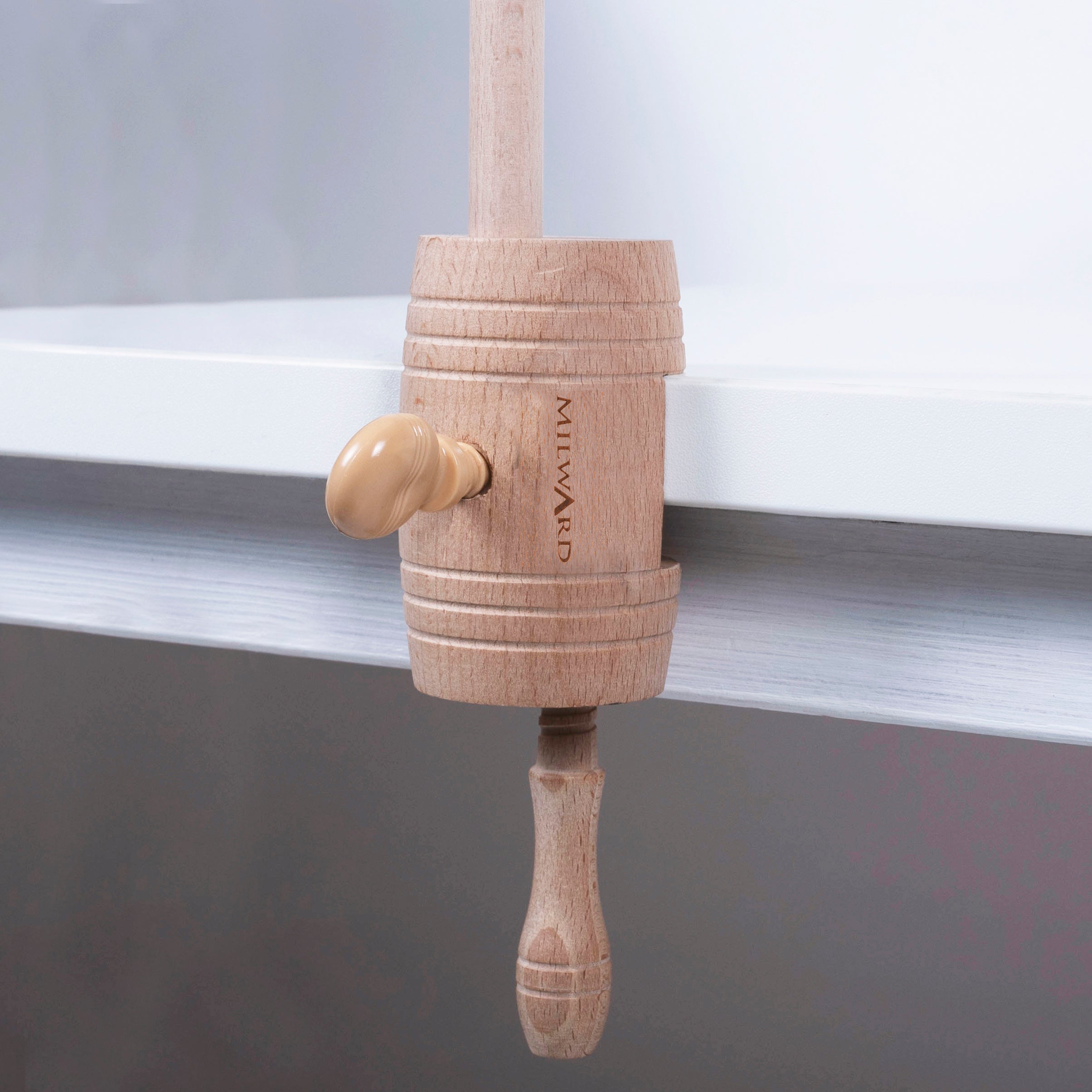 Milward beech wood table clamp for embroidery hoops and frames attached to a white desk edge.