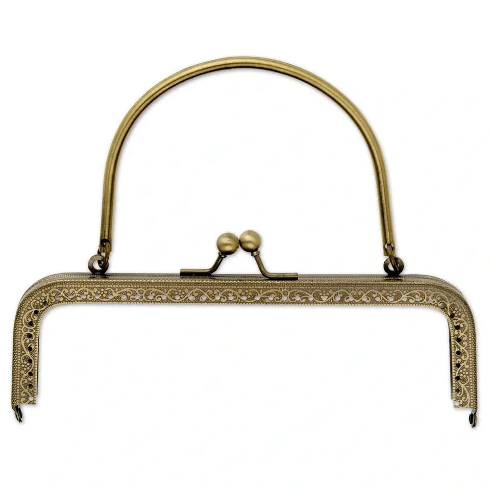 Antique brass metal bag frame closure with a curved handle and ball clasp.