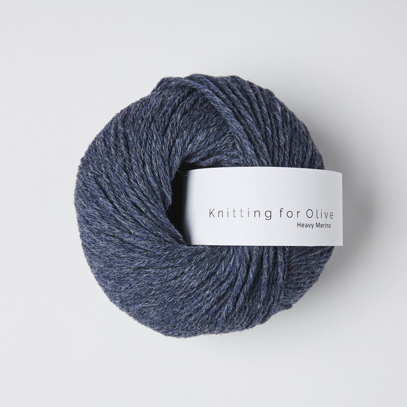 A ball of dark blue Heavy Merino wool yarn with a white label.