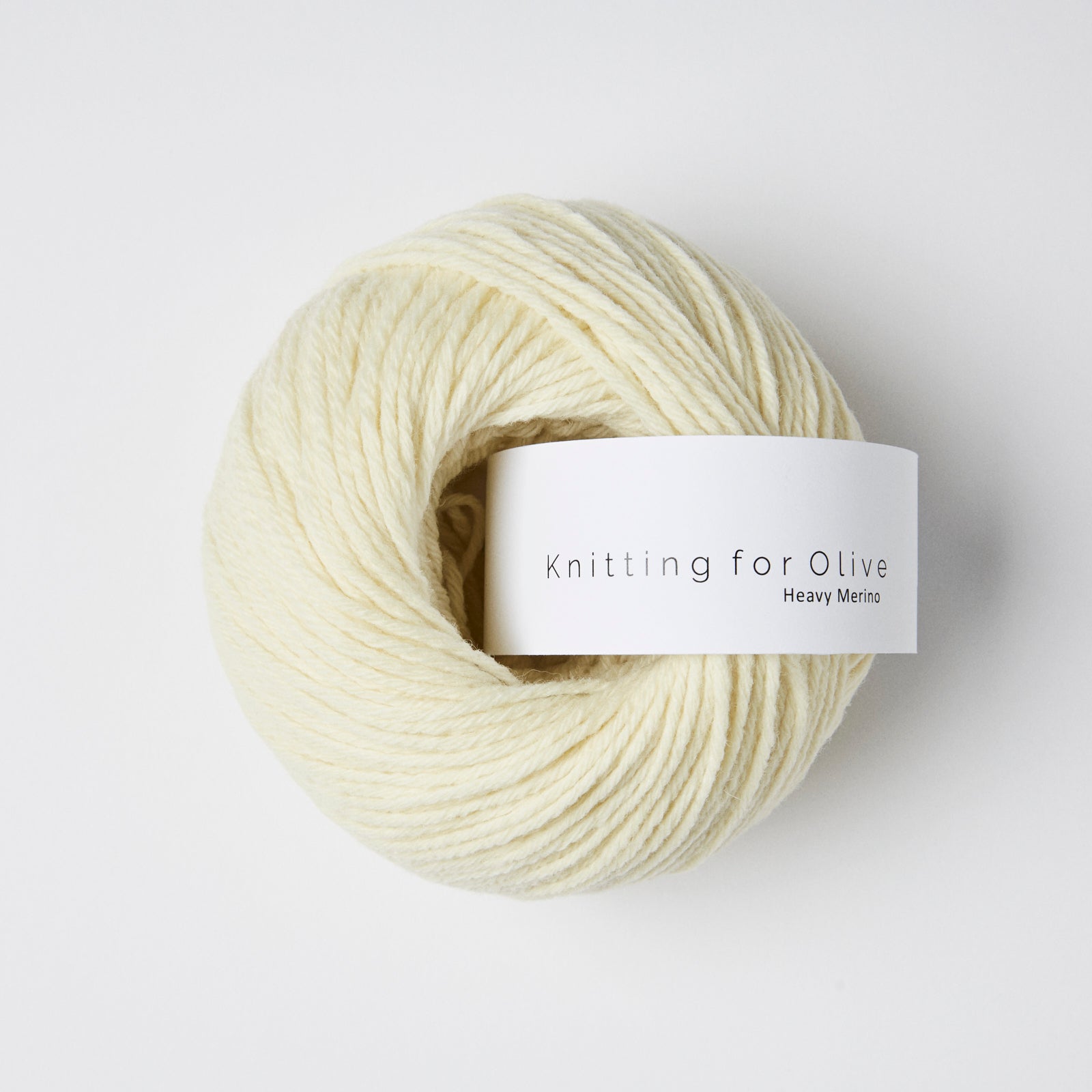 A ball of cream-colored Heavy Merino yarn with a white label.