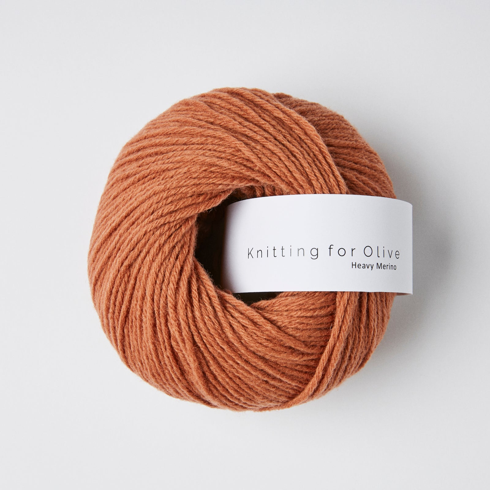A ball of rust-colored Heavy Merino yarn from Knitting For Olive.