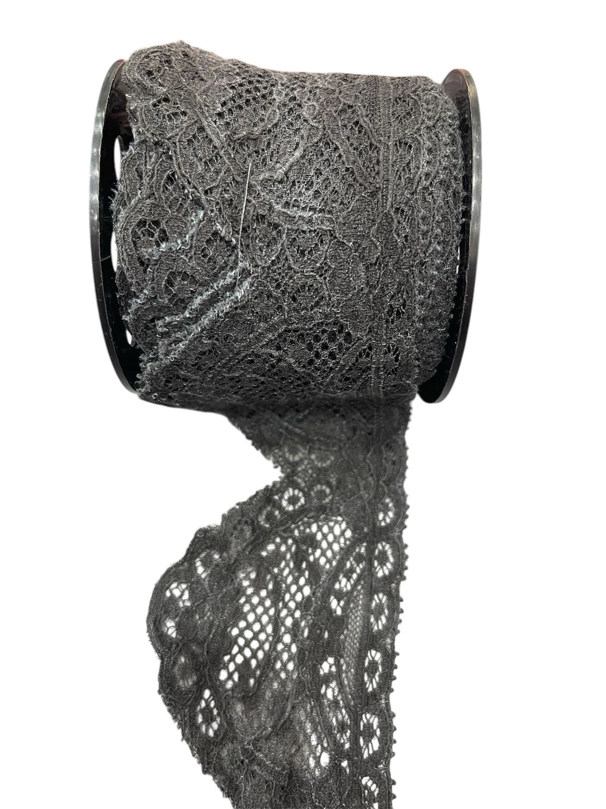 Dark grey embroidered lace trim on a spool.