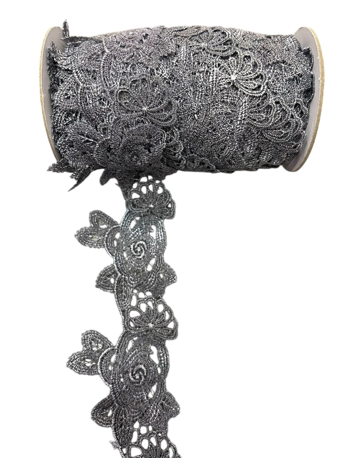 A spool of grey crochet lace ribbon with a floral pattern.