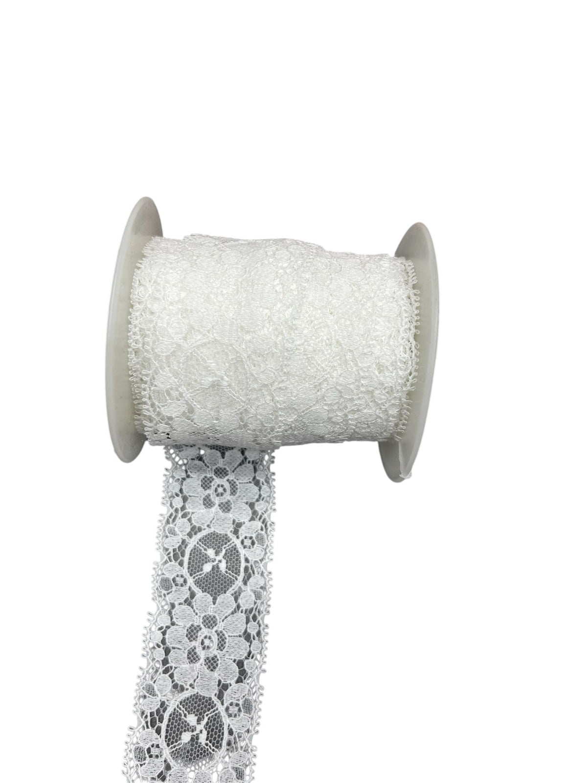 White crochet lace ribbon on a spool with a length hanging down.