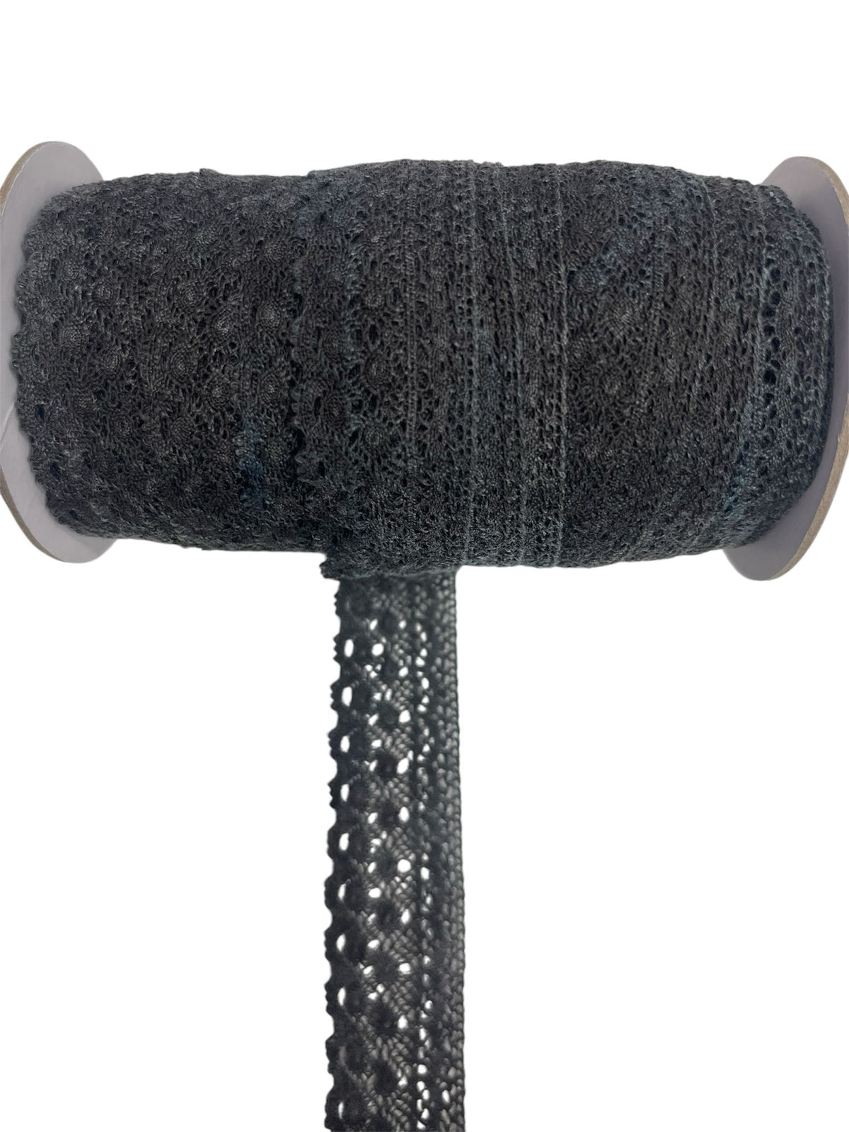 Dark grey crochet lace ribbon on a spool.