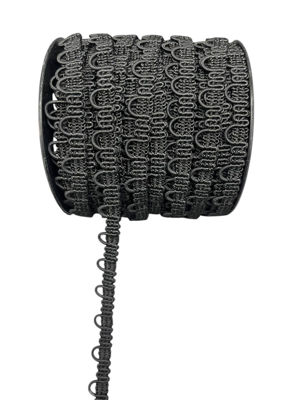 Black decorative lace trim cord on a spool with a hanging strand.