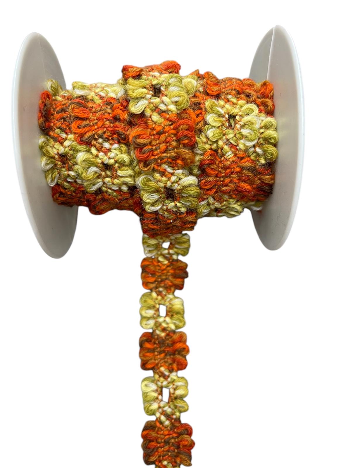 Decorative trim cord with floral pattern in orange and green on a spool.