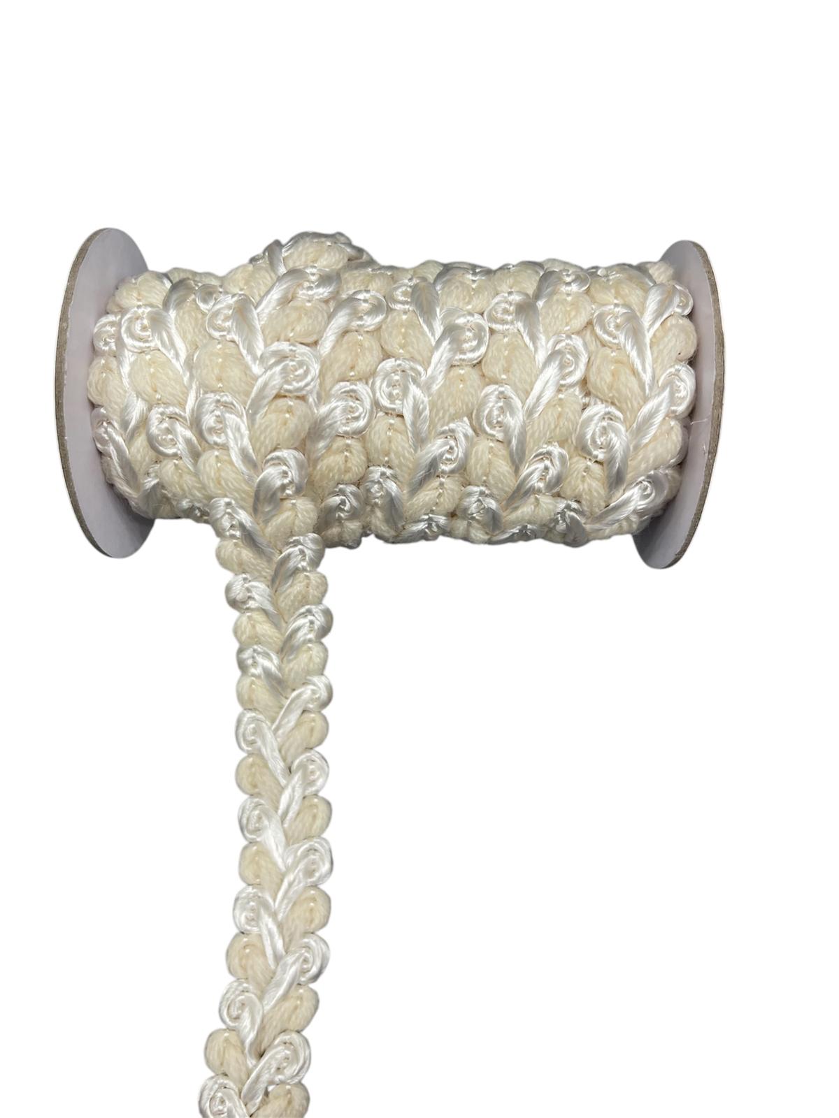 Cream decorative trim cord with a braided and looped design on a spool.