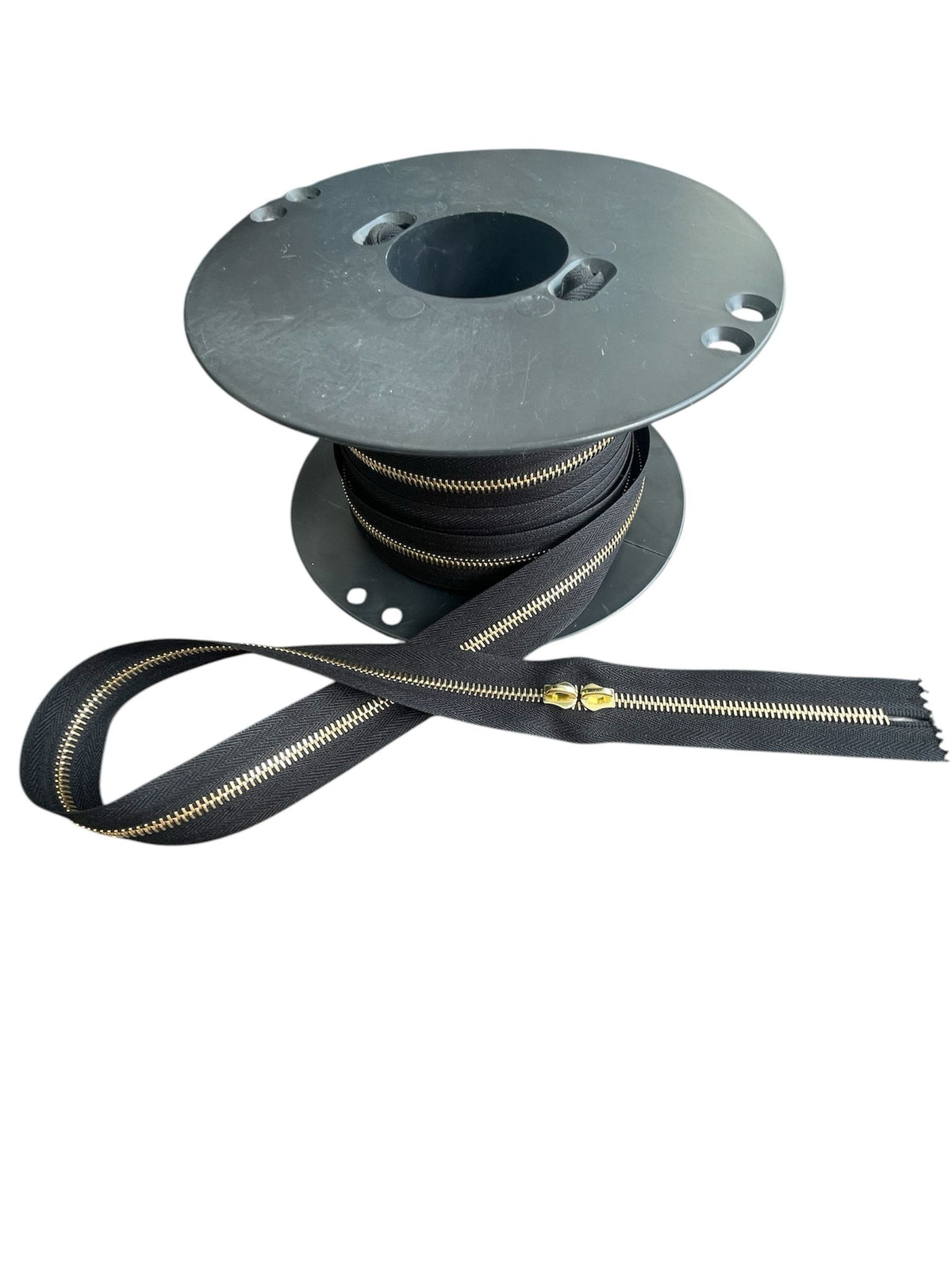 Riri M6 metal continuous zipper on a spool with gold teeth.