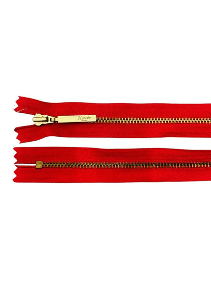 YKK size 3 closed end gold metal zipper on red fabric.