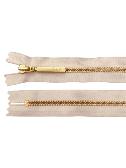 YKK Size 3 closed end gold metal zipper with beige tape.