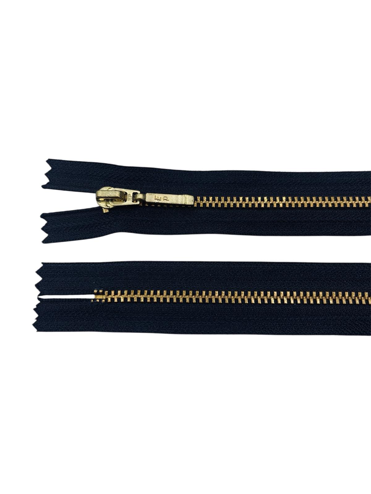 YKK size 3 closed end gold metal zipper on navy fabric.