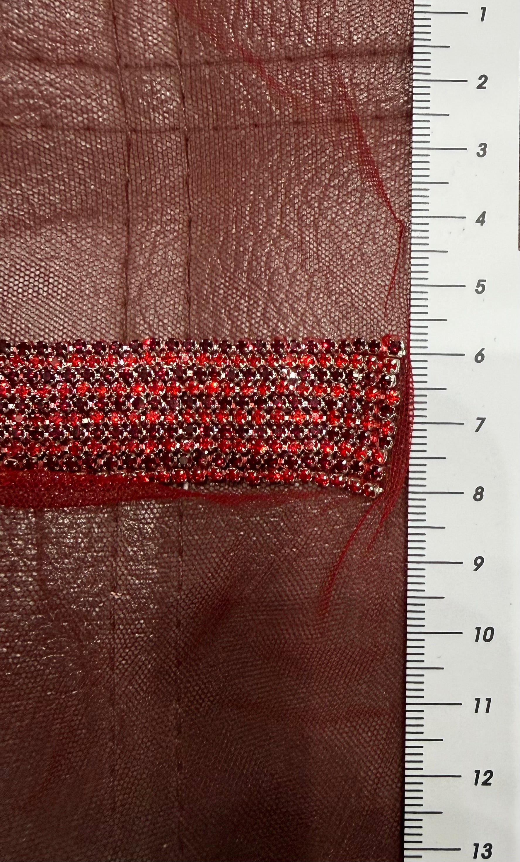 Hand beaded gem tape with red rhinestones on a sheer red mesh.