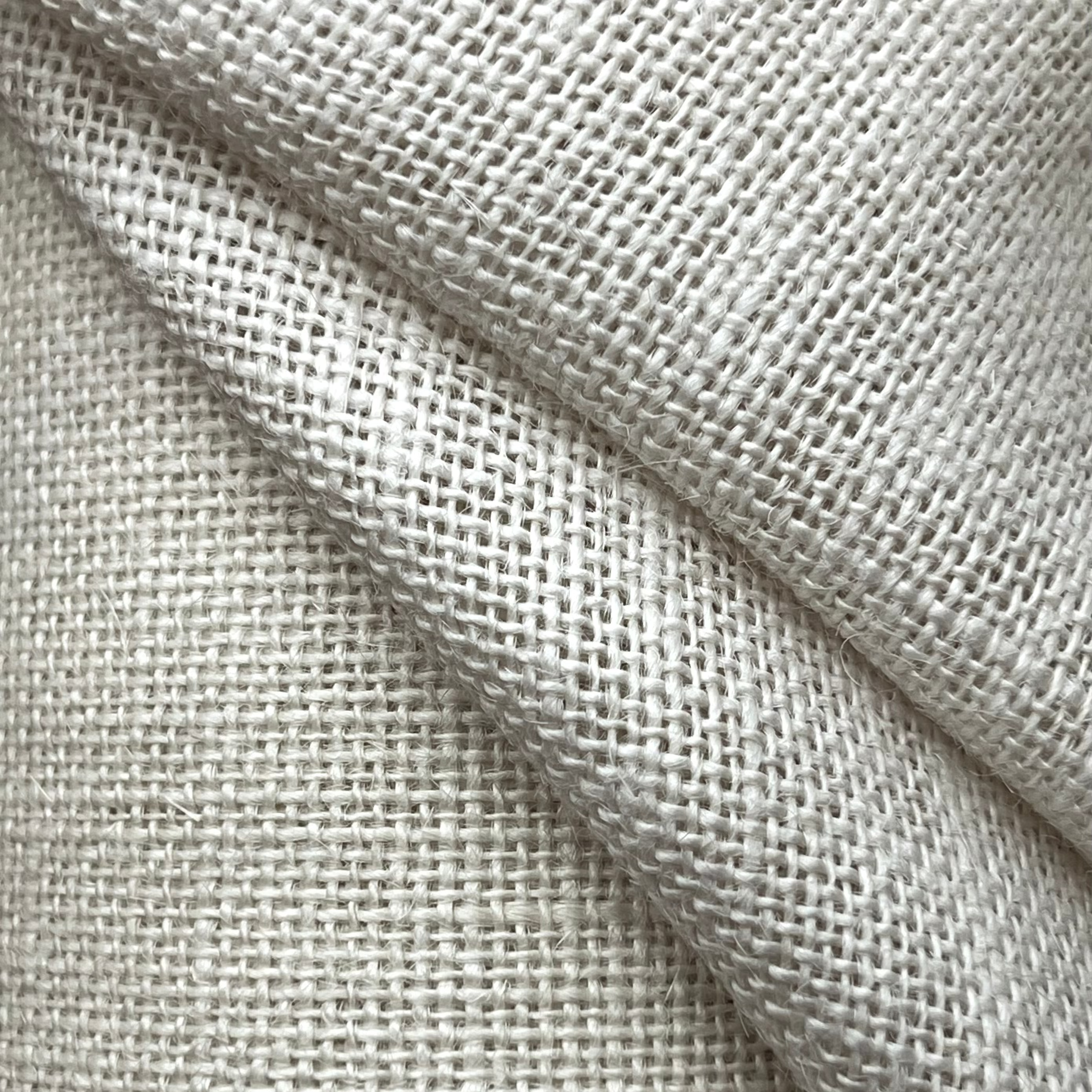 A close-up of stone-colored 16-count Aida needlecraft fabric.
